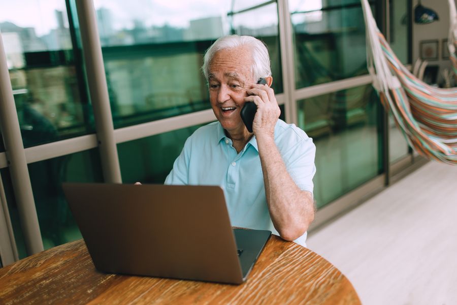 Smiling man on a phone call at his laptop