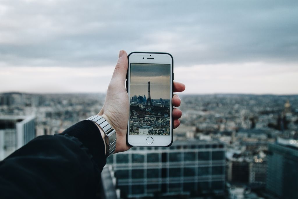 Traveller photographing the Eiffel Tower in Paris on a smartphone